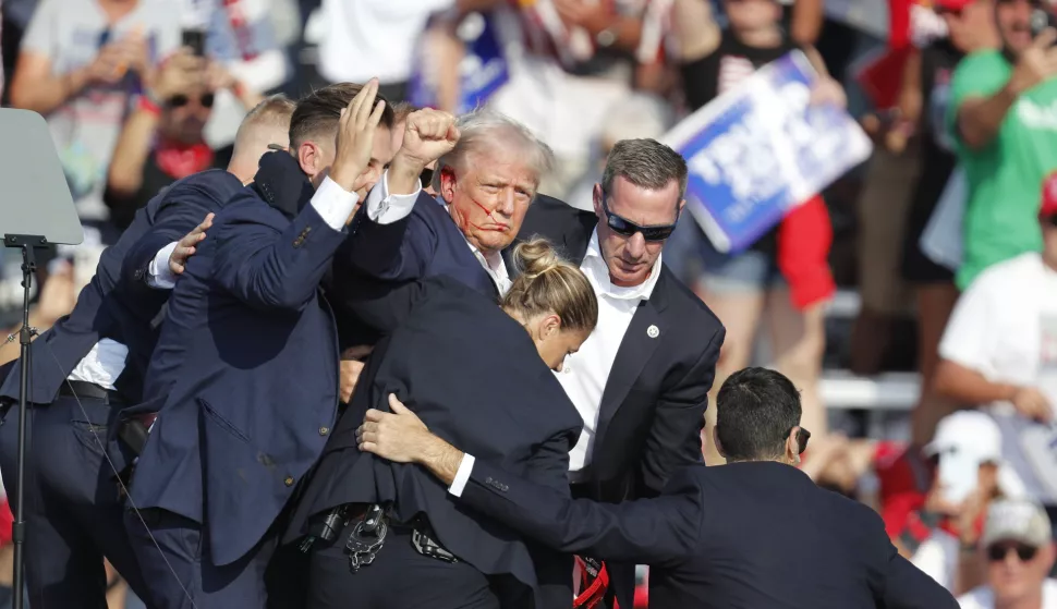 epa11476785 Former US President Donald Trump pumps his fist as he is rushed from stage by secret service after an incident during a campaign rally at the Butler Farm Show Inc. in Butler, Pennsylvania, USA, 13 July 2024. Trump was rushed off stage by secret service after an incident during a campaign rally in Pennsylvania. According to the Butler County district attorney a suspected gunman was dead and at least one rally attendee was killed. According to a statement by a secret service spokesperson, the former President is safe and further information on the incident will be released when available. EPA/DAVID MAXWELL