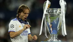 epa09983388 Luka Modric of Real Madrid reacts next to the trophy after winning the UEFA Champions League final between Liverpool FC and Real Madrid at Stade de France in Saint-Denis, near Paris, France, 28 May 2022. EPA/YOAN VALAT