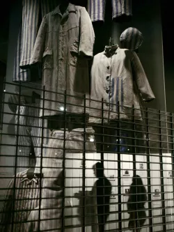 Visitors to the U.S. Holocaust Memorial Museum walk past a display of concentration camp clothing, in Washington January 26, 2007. Saturday marks the 2nd International Holocaust Remembrance Day and is the 62nd anniversary of the liberation of the Auschwitz-Birkenau concentration camp in 1945. REUTERS/Jim Young (UNITED STATES)