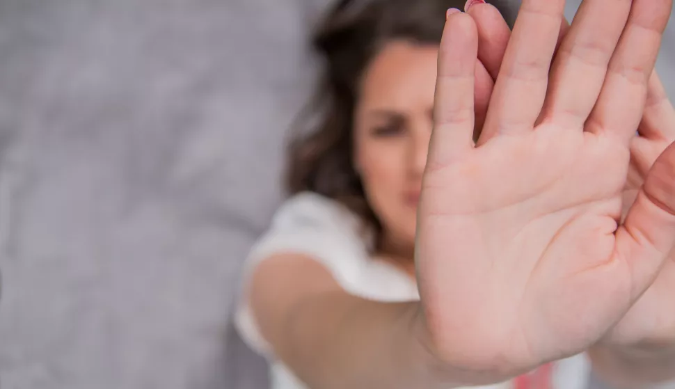 Young woman showing her denial with NO on her hand. Focus on hand. Timid woman symbol of violence in the familyobiteljsko nasilje ilustracijafreepik