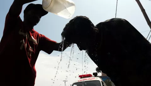 epa11488033 A man tries to cool off by getting water poured on his head at a roadside camp set up by the Edhi Foundation, as the heat wave continues in Karachi, Pakistan, 19 July 2024. The heatwave in Karachi has led to the hospitalization of 1,592 individuals at Jinnah Hospital within the past 24 hours, resulting in 49 fatalities, including 29 brought in dead, according to doctors. The city, currently experiencing extreme heat due to the suspension of sea breeze with temperatures soaring to a record 42 degree Celsius. Residents are advised to avoid sun exposure between 10am and 4pm. EPA/REHAN KHAN