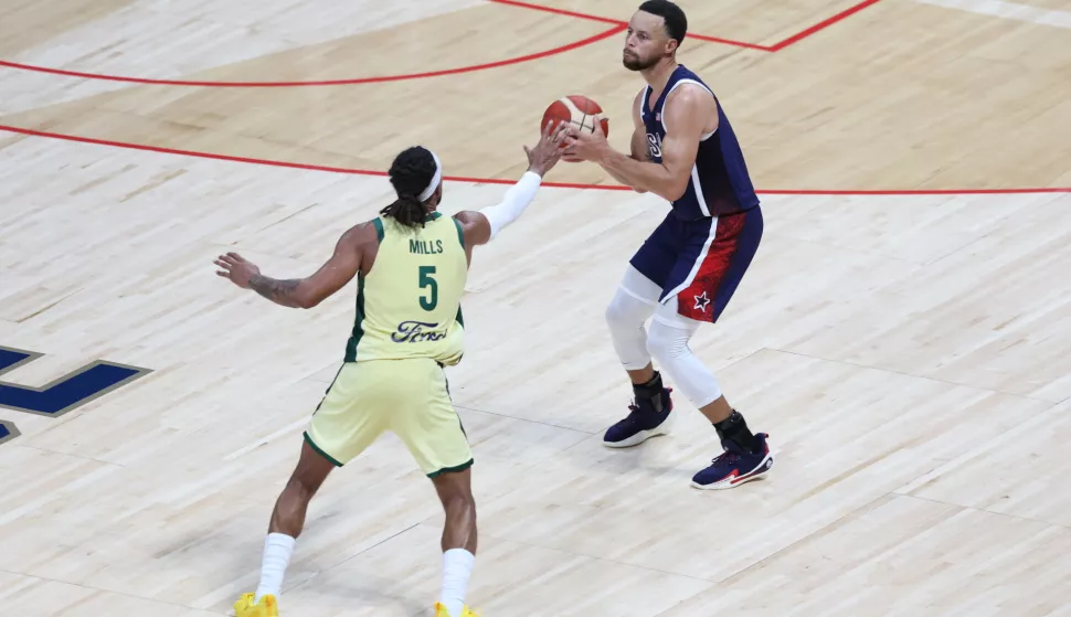 epa11480332 Stephen Curry (R) of the USA and Patty Mills of Australia in action during the 2024 USA Basketball Showcase game between USA and Australia in Abu Dhabi, United Arab Emirates, 15 July 2024. EPA/ALI HAIDER