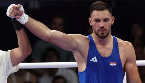 epa11508297 Gabrijel Veocic of Croatia (blue) celebrates winning against Hussein Iashaish of Jordan (not pictured) after their Men's 80kg round of 16 bout of the Boxing competitions in the Paris 2024 Olympic Games, at the North Paris Arena in Villepinte, France, 30 July 2024. EPA/DANIEL IRUNGU