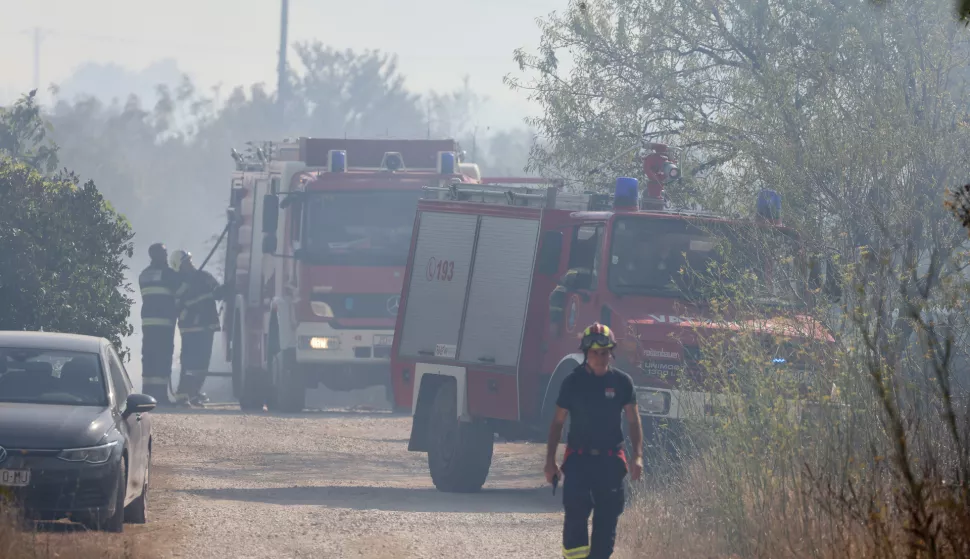 Smoković, 30.07.2024. -Požer koji je buknuo u prijepodnevnim satima na potezu od Smokovića do Zemunika, a vatra je zahvatila i vojarnu u Zemuniku, još uvijek je aktivan. Vatrogasci se svim silama trude staviti požar pod kontorlu. Na požaru kod Smokovića na terenu su 42 vatrogasca sa 19 vozila, 3 Canadaira te 4 Air Tractora.Foto HINA/Zvonko KUCELIN