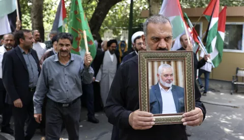 epa11510973 Iranians carry the portrait of late Hamas political leader Ismail Haniyeh and wave Palestinian flags during a protest at Tehran University in Tehran, Iran, 31 July 2024. According to an Iranian Revolutionary Guard Corps (IRGC) statement on 31 July, Hamas political leader Ismail Haniyeh and one of his bodyguards were targeted and killed in Tehran on 31 July 2024. EPA/ABEDIN TAHERKENAREH