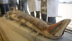 epa07714573 Archeologists display a mummy that was discovered during archaeological excavation almost 300 meters south of King Amenemhat II pyramid at Dahshur necropolis, some 40kms south of Cairo, Egypt, 13 July 2019. Egyptian ministry of antiquities said an archaeological mission discovered a collection of stone, clay and wooden sarcophagi, of which some are still containing well preserved mummies, as well as a collection of wooden funerary masks and instruments used in cutting stones. EPA/MOHAMED HOSSAM