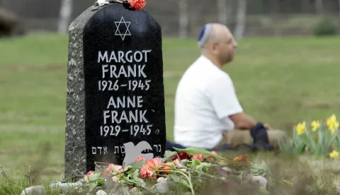 epa000413423 Asher Bivas sits beside a memorial stone for Anne and Margot Frank at the former concentration camp Bergen-Belsen on the occasion of the 60th anniversary of the camp's liberation in Belsen, Germany, Friday, 15 April 2005. Anne Frank was transferred from concentration camp Ausschwitz to Bergen-Belsen 30 October 1944 and died there together with Margot of typhus in in February 1945. Asher Bivas is the son of a camp survivor. 100,000 prisoners from 40 countries, among those 50,000 Soviet prisoners of war and 30,000 Jews, died in the camp. The official memorial service takes place in Belgen-Belsen on Sunday, 17 April 2005. EPA/Rainer Jensen