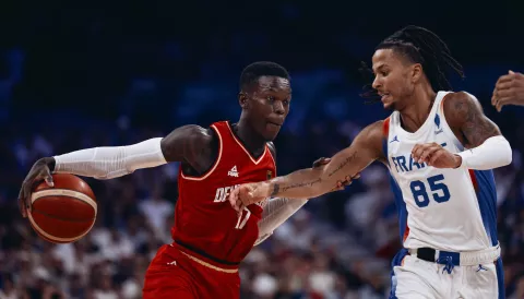 epa11520654 Dennis Schroder of Germany (L) in action against Matthew Strazel of France (R) during the Men Basketball Group B match between France and Germany in the Paris 2024 Olympic Games, at the Pierre Mauroy Stadium in Villeneuve-d'Ascq, France, 02 August 2024. EPA/ALEX PLAVEVSKI