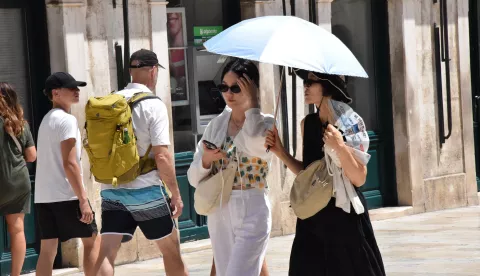 Dubrovnik, 21.7.2024.- Velika vru?ina nije bila smetnja brojnim gostima Dubrovnika za ?etnju gradom i obilazak znamenitosti u nedjelju ujutro. Foto HINA/ Baldo MARUN?I?/ bm