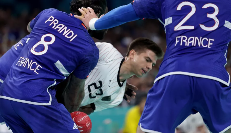 epa11533078 Renars Uscins (C) of Germany in action against Elohim Prandi (L) of France during the quarter - final game between Germany and France of the Handball competitions in the Paris 2024 Olympic Games, at the Pierre Mauroy Stadium in Villeneuve-d'Ascq, France, 07 August, 2024. EPA/ALEX PLAVEVSKI