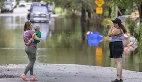 epa11532100 Two persons stand in front of a flooded street after the rain from Tropical Storm Debby in Charleston, South Carolina, USA, 06 August 2024. According to the National Hurricane Center, Debby made landfall in Florida's Big Bend as a hurricane and is now a tropical storm that can produce potentially historic heavy rainfall across southeast Georgia, part of South Carolina, and southeast North Carolina. EPA/CRISTOBAL HERRERA-ULASHKEVICH