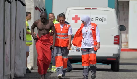 epa11547757 Red Cross members attend a man who arrived in a 'cayuco' (small wooden boat) within a group of 97 migrants at the port of La Restinga, in El Hierro, Canary Islands, Spain, 13 August 2024. EPA/GELMERT FINOL