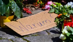 epaselect epa11562807 A placard reading 'Why?' among flowers and tributes placed on a sidewalk near the scene after a knife attack, in Solingen, Germany, 24 August 2024. A man stabbed passers-by at random with a knife during the city festival in Solingen on 23 August evening. Three people have been killed and eight others injured, five of them seriously, in the knife attack, police said. Police announced the arrest of a person in connection with the attack as part of a large-scale manhunt for the perpetrator. EPA/VOLKER HARTMANN