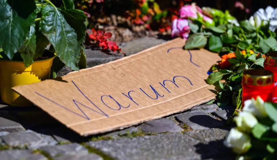 epaselect epa11562807 A placard reading 'Why?' among flowers and tributes placed on a sidewalk near the scene after a knife attack, in Solingen, Germany, 24 August 2024. A man stabbed passers-by at random with a knife during the city festival in Solingen on 23 August evening. Three people have been killed and eight others injured, five of them seriously, in the knife attack, police said. Police announced the arrest of a person in connection with the attack as part of a large-scale manhunt for the perpetrator. EPA/VOLKER HARTMANN