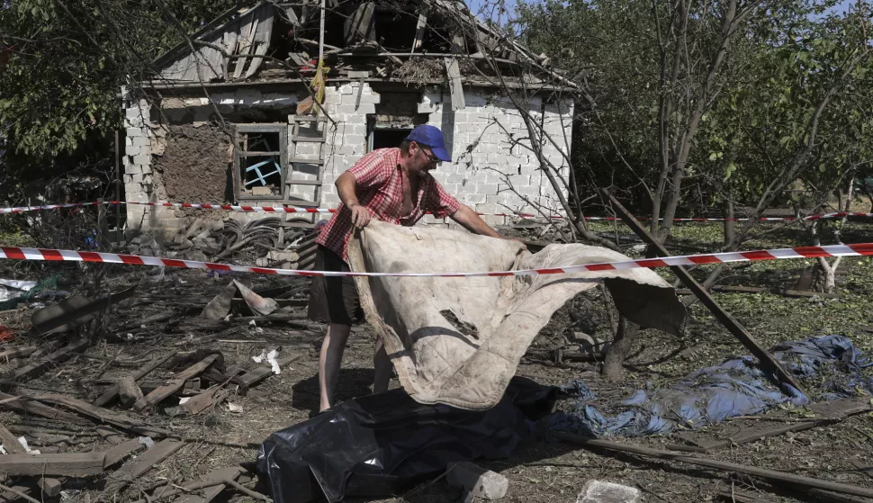 epa11565481 A local man covers the body of a killed local woman at the site of a rocket hit in a village in the Zaporizhzhia area, Ukraine, 26 August 2024, after a morning of combined shelling around the entire territory of Ukraine. Ukrainian President Volodymyr Zelensky wrote on his telegram channel that Ukraine experienced a heavy Russian missile and drone attack. The attack targeted critical civilian infrastructure across the country, resulting in casualties and injuries. The Ukrainian president expressed his condolences to the victims' families and assured that injured people are receiving necessary assistance. Russian troops entered Ukrainian territory on 24 February 2022, starting a conflict that has provoked destruction and a humanitarian crisis. EPA/KATERYNA KLOCHKO