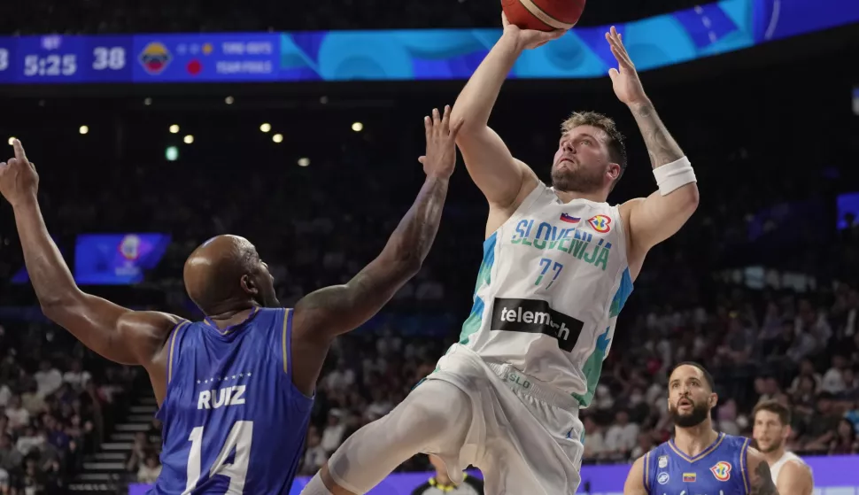 epa10821435 Luka Doncic (R) of Slovenia in action against Miguel Ruiz of Venezuela during the FIBA Basketball World Cup 2023 group stage match between Slovenia and Venezuela in Okinawa, Japan, 26 August 2023. EPA/KIMIMASA MAYAMA