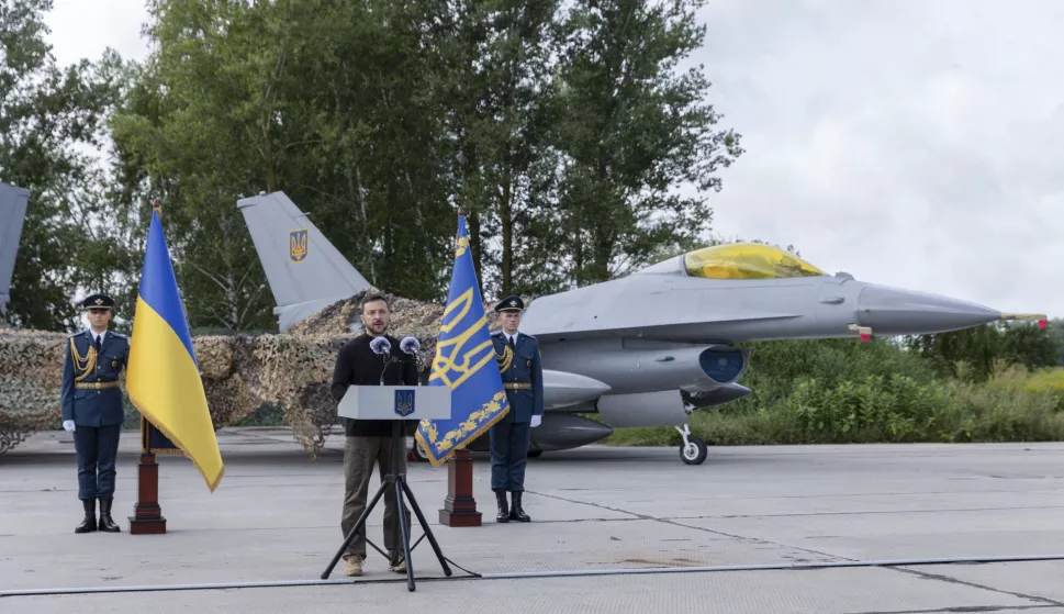 epa11525679 A handout picture made available by the Presidential Press Service shows Ukrainian President Volodymyr Zelensky speaking to servicemen next to an American single-engine supersonic multirole fighter F-16 jet during a ceremony to mark Air Force Day of the Armed Forces of Ukraine at an undisclosed location in Ukraine, 04 August 2024, amid the Russian invasion. Zelensky emphasized that the number of F-16 aircraft and trained pilots is still insufficient, as the country waits for additional fighters from partner countries. EPA/PRESIDENTIAL PRESS SERVICE HANDOUT HANDOUT EDITORIAL USE ONLY/NO SALES