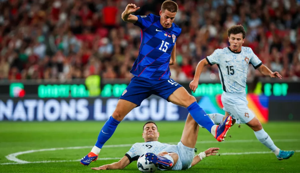 epa11588247 Joao Neves (R) and Diogo Dalot (bottom) of Portugal in action against Mario Pasalic of Croatia during the UEFA Nations League group A soccer match between Portugal and Croatia, in Lisbon, Portugal, 05 September 2024. EPA/JOSE SENA GOULAO