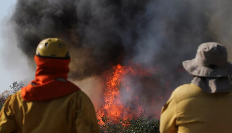 FILE PHOTO: Firefighters look at burning vegetation as the Santa Cruz departmental government has decreed a state of emergency due to extreme weather including wildfires, in San Lorenzo de Robore, Bolivia July 24, 2024. REUTERS/Jorge Parada/File Photo