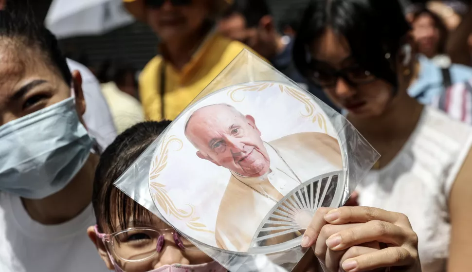 epa11599600 A girl holds a fan with a picture of Pope Francis as she queues ahead of the Holy Mass led by the Pope at the National Stadium in Singapore, 12 September 2024. Pope Francis is visiting Singapore from 11 to 13 September, marking the final stop of his apostolic journey through the Asia-Pacific region, which also included Indonesia, Papua New Guinea, and East Timor. EPA/HOW HWEE YOUNG