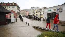 epa11605256 People pass by next to a flooded street after the heavy rainfalls caused the flooding in Klodzko, southwestern Poland, 15 September 2024. The next 24-36 hours will be crucial for the southern regions of Poland experiencing record downpours. On 14 September, the Institute of Meteorology and Water Management (IMGW) reported that the water level exceeded the alarm condition at 41 hydrological stations and the warning condition at 30 stations. EPA/Maciej Kulczynski POLAND OUT