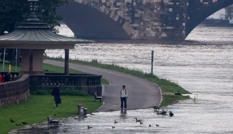 epa11609155 A pedestrian checks water level of swollen Elbe river in Dresden, Saxony, Germany, 17 September 2024. The Elbe river's water level is expected to reach six meters in the Dresden area, according to the State Flood Center. Floods caused by heavy rains have been battering central and eastern Europe since 13 September, with at least six dead in Romania, one dead and several missing in the Czech Republic, and alarming water levels recorded in Poland. EPA/Filip Singer