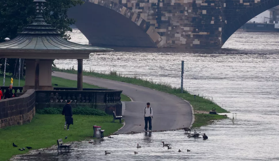 epa11609155 A pedestrian checks water level of swollen Elbe river in Dresden, Saxony, Germany, 17 September 2024. The Elbe river's water level is expected to reach six meters in the Dresden area, according to the State Flood Center. Floods caused by heavy rains have been battering central and eastern Europe since 13 September, with at least six dead in Romania, one dead and several missing in the Czech Republic, and alarming water levels recorded in Poland. EPA/Filip Singer