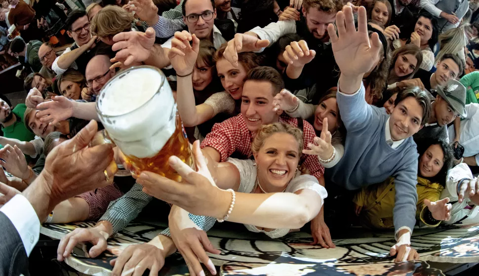 epa10189548 Visitors reach out for free beer in the Paulaner beer tent during the opening of the 187th edition of the traditional Oktoberfest beer and amusement festival in Bavaria's state capital of Munich, Germany, 17 September 2022. The Oktoberfest 2022 runs from 17 September to 03 October 2022 and several millions of visitors are expected from all over the world. The event resumes after being canceled for two years in a row due to the coronavirus disease (COVID-19) pandemic. EPA/CHRISTIAN BRUNA