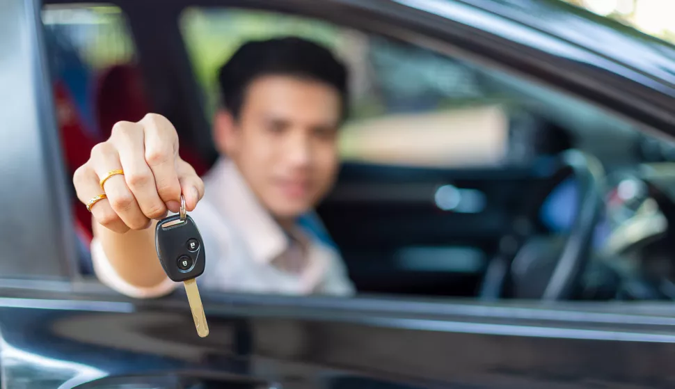 Selective focus on key remote of car in hand of handsome man with blurred young man smiling and sitting in the convertible carkljucevi, kljuc, auto, automobil, vozilofreepik