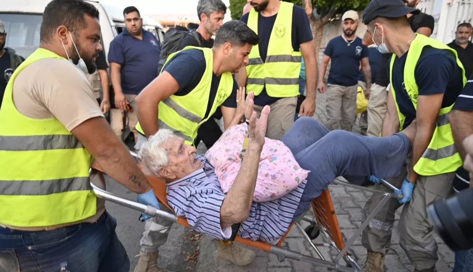 epa11621211 Volunteers assist an elderly man as people who fled southern Lebanon villages arrive at a makeshift shelter at an educational institution in Beirut, Lebanon, 23 September 2024. Thousands of Lebanese fled southern Lebanon after the Israeli army issued an evacuation warning. The Israeli military announced on 23 September that it launched 'extensive' airstrikes on Hezbollah targets in Lebanon. Lebanese residents of villages in the Beqaa Valley 'who are inside or near houses where rockets and weapons are stored' have been warned to 'move away immediately! For your safety and protection', the statement added. According to Lebanon's Ministry of Health, at least 274 people have been killed and more than 1,000 others injured following continued Israeli airstrikes on southern Lebanese towns and villages since 23 September morning. EPA/WAEL HAMZEH