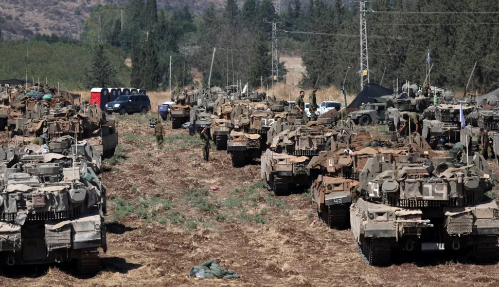 epa11627942 Israeli soldiers with their tanks gather at an undisclosed location in northern Israel, 27 September 2024. Israel's military stated on 27 September, that the Israel Air Force (IAF) launched dozens of strikes targeting Hezbollah cells and infrastructure in several areas in southern Lebanon. EPA/ATEF SAFADI