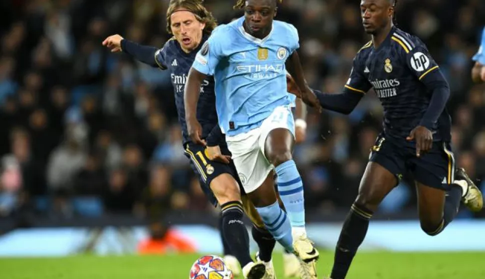 epa11285465 Jeremy Doku (C) of Manchester City in action against Luka Modric (L) and Eduardo Camavinga of Real Madrid during the UEFA Champions League quarter final, 2nd leg match between Manchester City and Real Madrid in Manchester, Britain, 17 April 2024. EPA/PETER POWELL