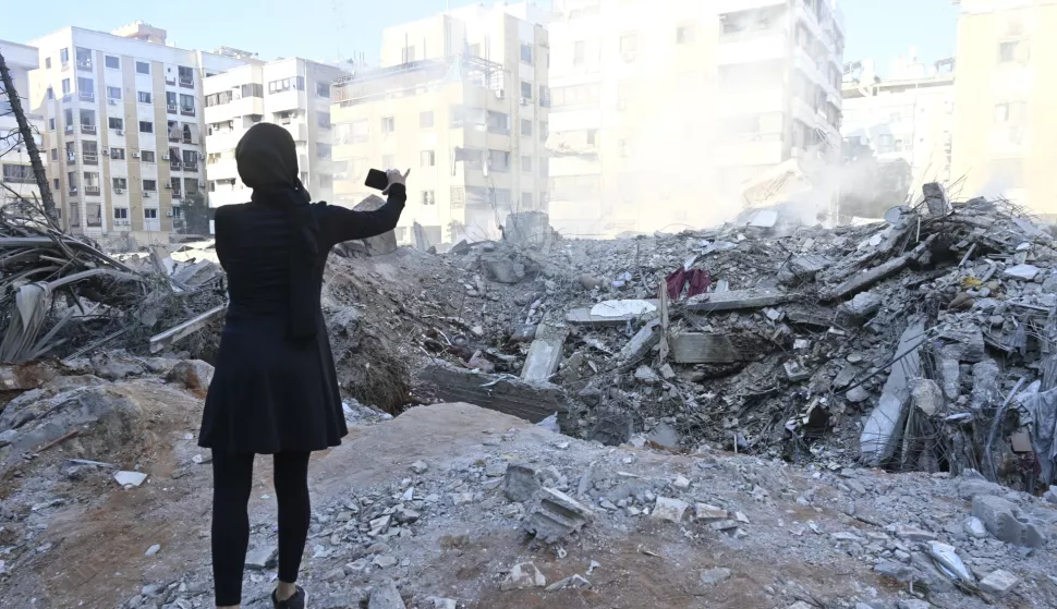 epaselect epa11631670 A woman takes photo of a destroyed building in the Haret Hreik neighborhood of Beirut's southern suburbs, after Israeli military strikes on Beirut, Lebanon, 29 September 2024. According to the UN Humanitarian Coordinator in Lebanon Imran Riza, the recent escalations in Lebanon, a 'catastrophic situation', have led to widespread destruction of homes and infrastructure across the country. At least 700 people have been killed, thousands have been injured, and nearly 120,000 people have been displaced in the past week. The Israeli army (Tsahal) said on 28 September 2024 on X (formerly Twitter) that Hezbollah leader Hassan Nasrallah was killed in an overnight strike on Beirut. Hezbollah confirmed the death of Nasrallah in a statement on 28 September 2024. EPA/WAEL HAMZEH