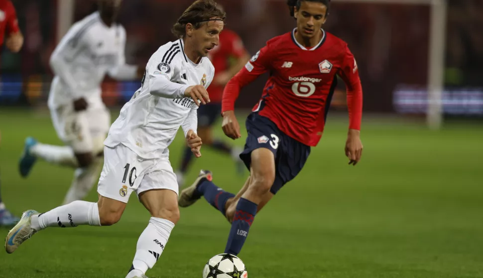 epa11638982 Luka Modric (L) of Real Madrid in action against Ayyoub Bouaddi of Lille during the UEFA Champions League match between Lille and Real Madrid in Lille, France, 02 October 2024. EPA/MOHAMMED BADRA