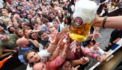 epa11616930 Visitors gather for the handing out of the first beer at the Paulaner brewery tent during the opening of the 189th edition of the traditional Oktoberfest beer and amusement festival in the Bavarian capital Munich, Germany, 21 September 2024. According to its organizers, the Oktoberfest has grown into the world's largest folk festival, drawing around six million visitors annually. The festival's 189th edition will run from 21 September to 06 October 2024 on the Theresienwiese. EPA/ANNA SZILAGYI