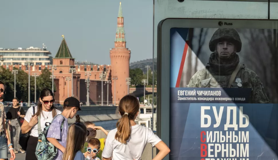 epa11555255 People walk past a bus stop with an advertising poster calling for military conscription, in front of the Kremlin in Moscow, Russia, 19 August 2024. According to Deputy Chairman of the Russian Security Council and leader of the ruling United Russia party Dmitry Medvedev, since the beginning of 2024, almost 200,000 people have signed contracts for military service in the Russian army. EPA/YURI KOCHETKOV