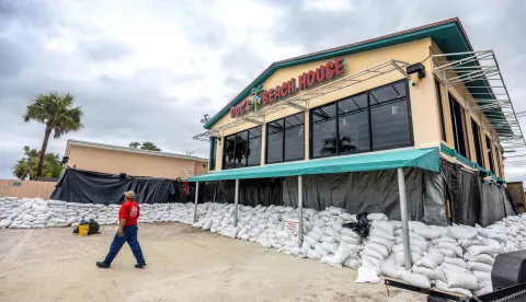 epa11649878 A person walks in front of a restaurant surrounded by sand bags as the city prepares for Hurricane Milton in Bonita Beach, Florida, USA, 08 October 2024. According to the National Hurricane Center's Live Hurricane Tracker, Hurricane Milton is set to make landfall on the west coast of Florida Wednesday evening. After rapidly intensifying into a Category 5 storm on Monday, Milton is anticipated to weaken as it reaches the shore but will still bring significant weather impacts across the state. EPA/CRISTOBAL HERRERA-ULASHKEVICH