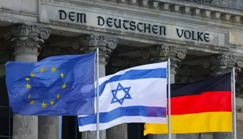 epa10912832 An Israeli flag flutters between a German and an EU flag before a minute of silence for the Israeli victims of the deadly attacks by the Palestinian militant group Hamas, during a debate at the German parliament Bundestag in Berlin, Germany, 11 October 2023. EPA/HANNIBAL HANSCHKE