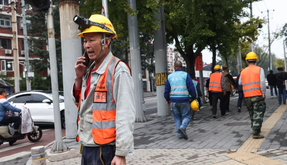 epa11665909 A construction worker uses his cellphone on a street in Beijing, China, 18 October 2024. China's urban surveyed unemployment rate fell to 5.1 percent in September 2024, according to data released by the National Bureau of Statistics of China on 18 October 2024. EPA/WU HAO