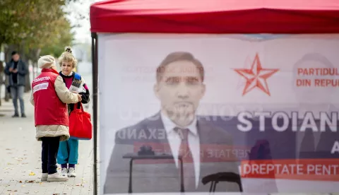 epa11662905 An elderly woman shares electoral leaflets in front of electoral tent in downtown Chisinau, Moldova, 16 October 2024. Moldova will hold presidential elections on 20 October 2024. EPA/DUMITRU DORU