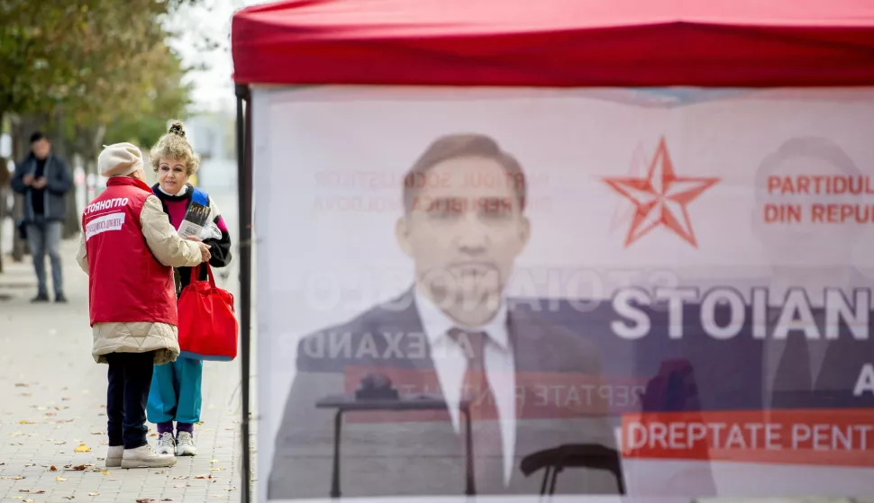 epa11662905 An elderly woman shares electoral leaflets in front of electoral tent in downtown Chisinau, Moldova, 16 October 2024. Moldova will hold presidential elections on 20 October 2024. EPA/DUMITRU DORU