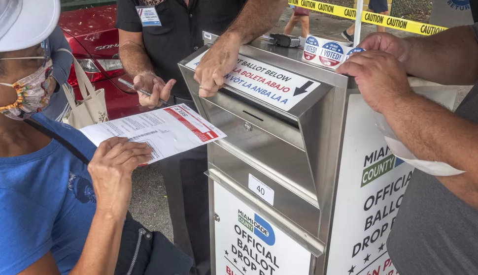 epa08757751 A voter casts her ballot in a Miami-Dade Official Ballot Drop Box to vote in the US Presidential Election during the first day of early voting in Miami, Florida, USA, 19 October 2020. The US presidential elections are scheduled for 03 November 2020. EPA/CRISTOBAL HERRERA-ULASHKEVICH