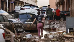 epa11694017 Residents walk through a damaged area caused by flooding and heavy rains in the municipality of Paiporta, province of Valencia, Spain, 31 October 2024. At least 95 people died in the province of Valencia and neighboring provinces following floods caused by the DANA (high-altitude isolated depression) phenomenon impacting the eastern part of the country. EPA/BIEL ALINO