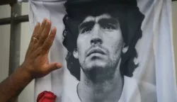 25 November 2020, Argentina, Buenos Aires: A fan puts his hand with a rose on a T-shirt with the picture of the football star Diego Maradona on the day he died. Maradona died in a house in Tigre north of Buenos Aires. Photo: Fernando Gens/dpa /DPA/PIXSELL