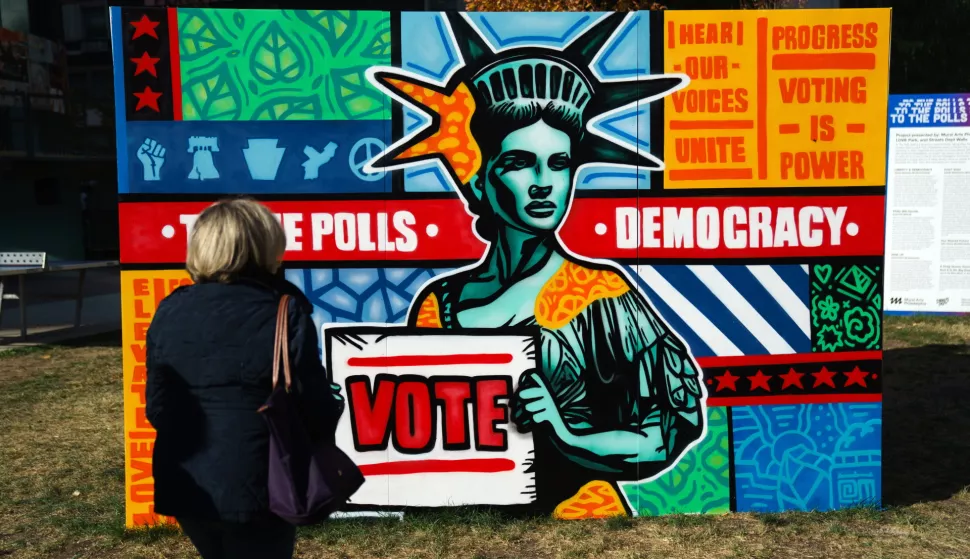 epa11690600 A woman passes signs encouraging early voting near Philadelphia City Hall in Philadelphia, Pennsylvania, USA, 29 October 2024. EPA/WILL OLIVER