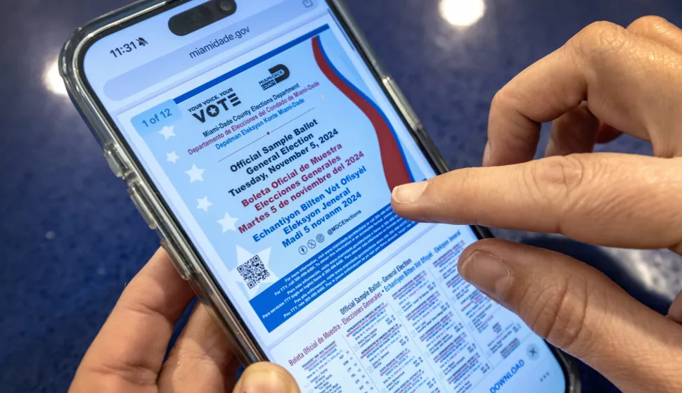 epa11680520 A person checks the official sample ballot on a mobile phone before voting during early voting for the 2024 US presidential election, in Miami, Florida, USA, 23 October 2024. The Miami-Dade County Elections Department has begun mailing official sample ballots to registered voters as the general election approaches. Voters can also view their customized sample ballots online. Voters in Florida can cast their ballots in person for the presidential election from 21 October, avoiding long lines on Election Day on 05 November 2024. EPA/CRISTOBAL HERRERA-ULASHKEVICH