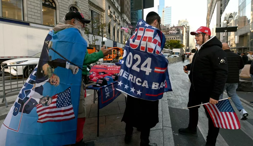 A Trump supporter buys a banner from a vendor on 6th Avenue and 34th Street near Madison Square Garden where former President Donald Trump is scheduled to hold a political rally, New York, NY, October 27, 2024. (Photo by Anthony Behar/Sipa USA) Photo: Anthony Behar/SIPA USA