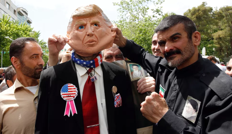 epa07560343 Demonstrators stand around an Iranian man that wears a mask of the US President Donald J. Trump during an anti-US rally, to show their support of Iran's decision to pull out from some part of nuclear deal, in Tehran, Iran, 10 May 2019. Media reported that on 08 May 2019 that President Hassan Rouhani announced Iran's decision to pull out from part of a 2015 international nuclear deal, a year after US President Trump pulled out of the agreement. The move was formally conveyed to ambassadors to countries remaining inside the deal (Germany, France, Russia, Britain and China). EPA/ABEDIN TAHERKENAREH