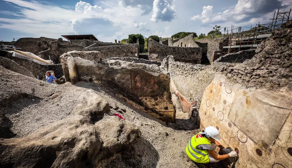 epa10662516 An archeologist works on a mural uncovered during excavation works at the Pompeii archeological site, in Pompeii, near Naples, Italy, 29 May 2023. The remains of three victims of the eruption of Vesuvius in 79 AD are among the latest archaeological finds uncovered during ongoing excavations at Pompeii, culture ministry officials said on 29 May. The skeletal remains are thought to be of two women and a child aged between 3 and 4 who had sought shelter in a bakery from the eruption that buried the ancient Roman commercial town in layers of lavic ash and pumice. Archaeologists have also found two frescoed walls featuring mythological scenes - Apollo and Daphne in one and Poseidon and Amymone in the other - near an atrium in the Regio IX, occupying the central part of Pompeii. EPA/CESARE ABBATE