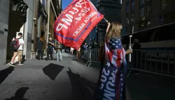 A woman wrapped in a Trump banner and waving a Trump flag, stands across the street from Trump Tower along 5th Avenue the day after the former President was re-elected to a second term in office, New York, NY, November 6, 2024. (Photo by Anthony Behar/Sipa USA) Photo: Anthony Behar/SIPA USA